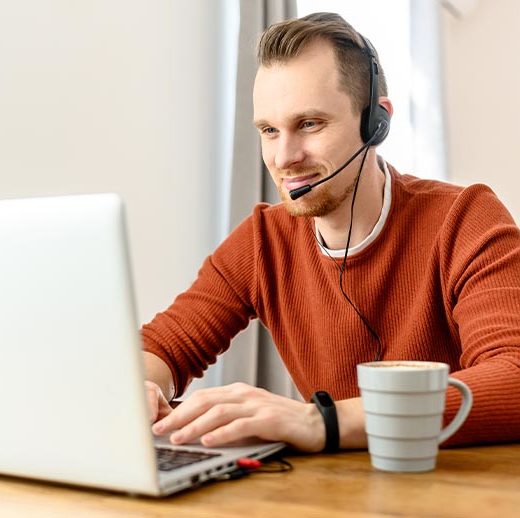 Man wearing a headset and working on his computer